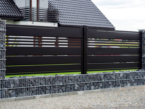Nowoczesne ogrodzenie domu od frontu - połączenie stalowych elementów z gabionami